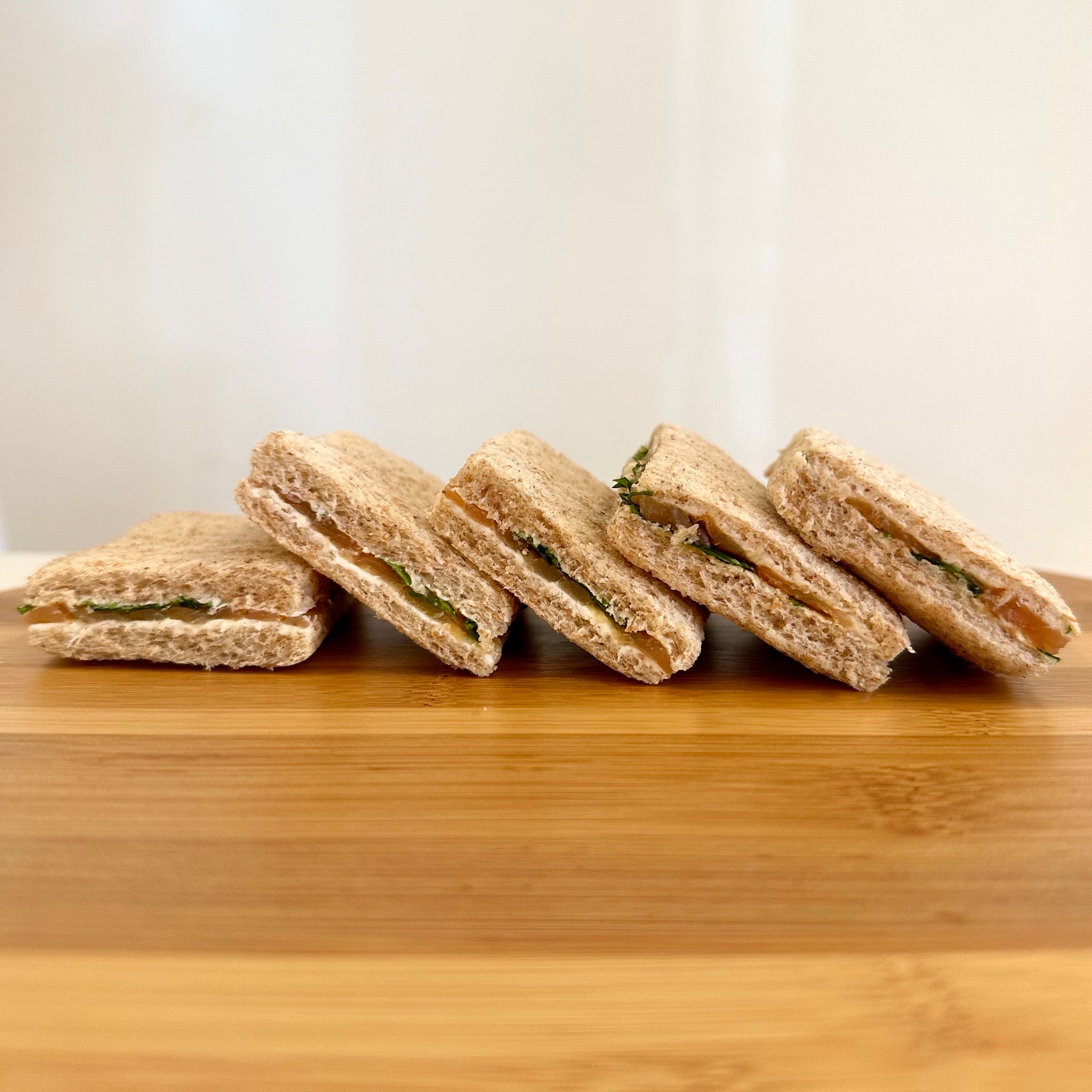 Bandeja de 8 mini sandwiches de pan de semillas con salmón rúcula y queso crema