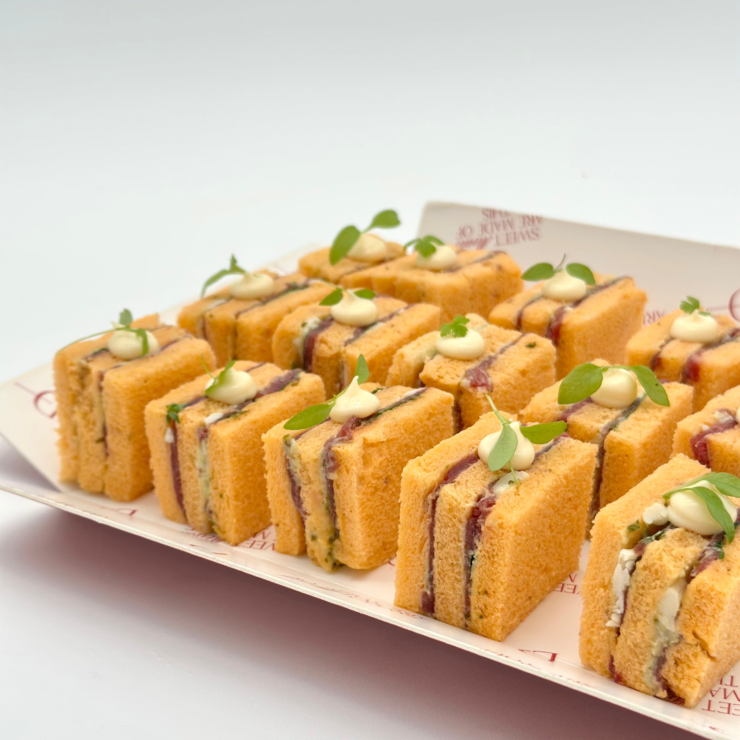 Pack de 24 mini sándwiches de carpaccio, rúcula, tomate seco y parmesano