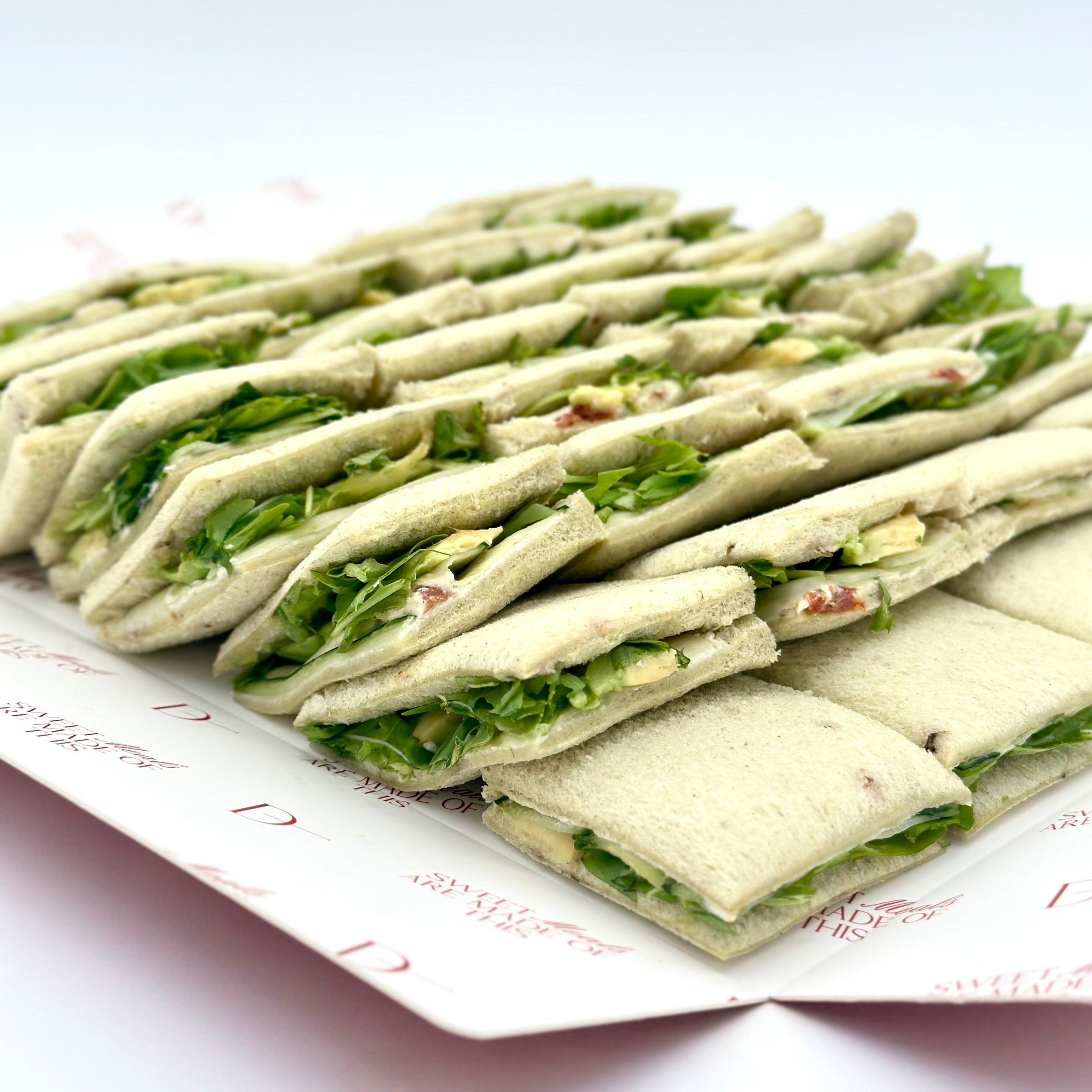 Pack de 8 mini sándwiches de pan de espinaca con aguacate, pepino, tomate seco, queso crema, pesto