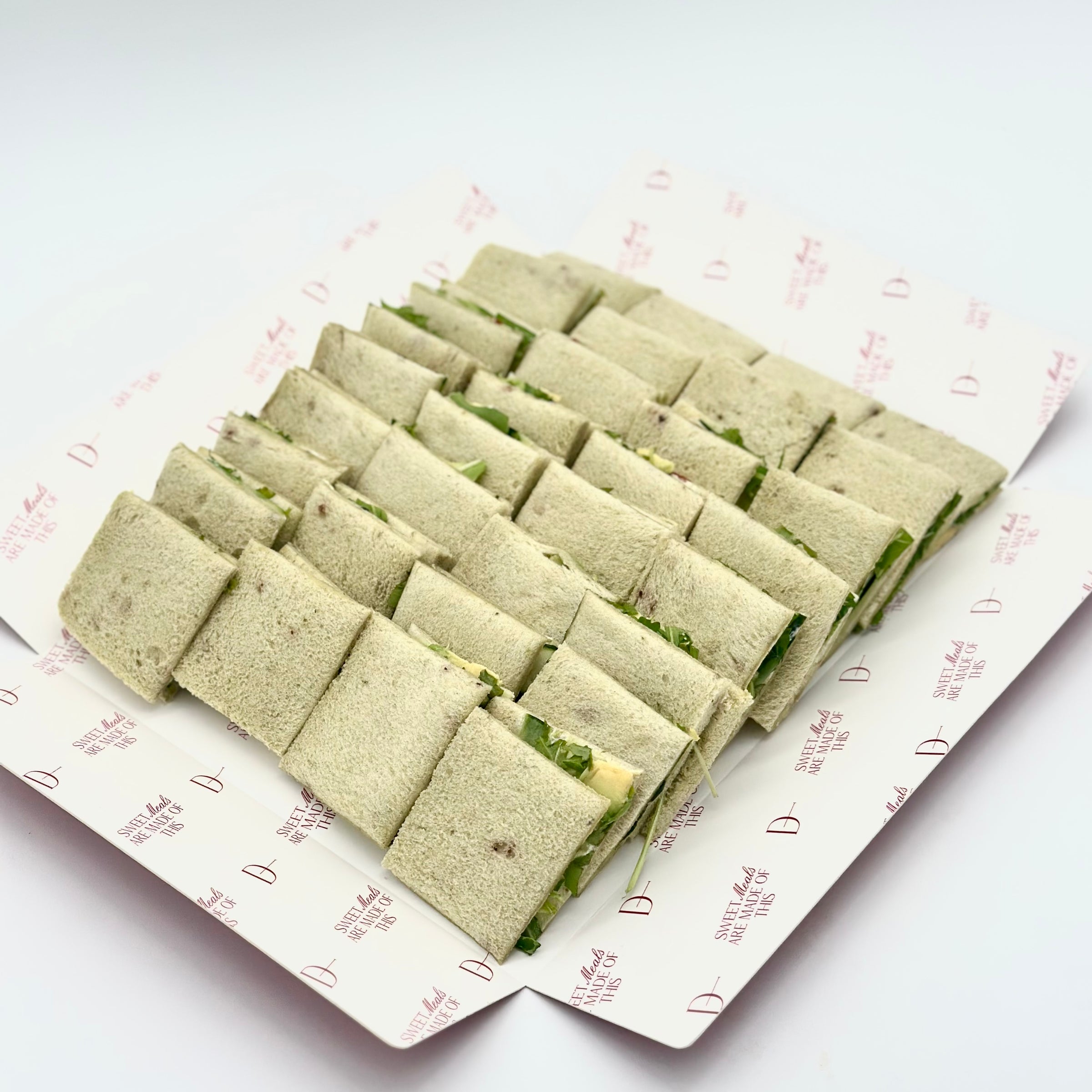 Pack de 8 mini sándwiches de pan de espinaca con aguacate, pepino, tomate seco, queso crema, pesto