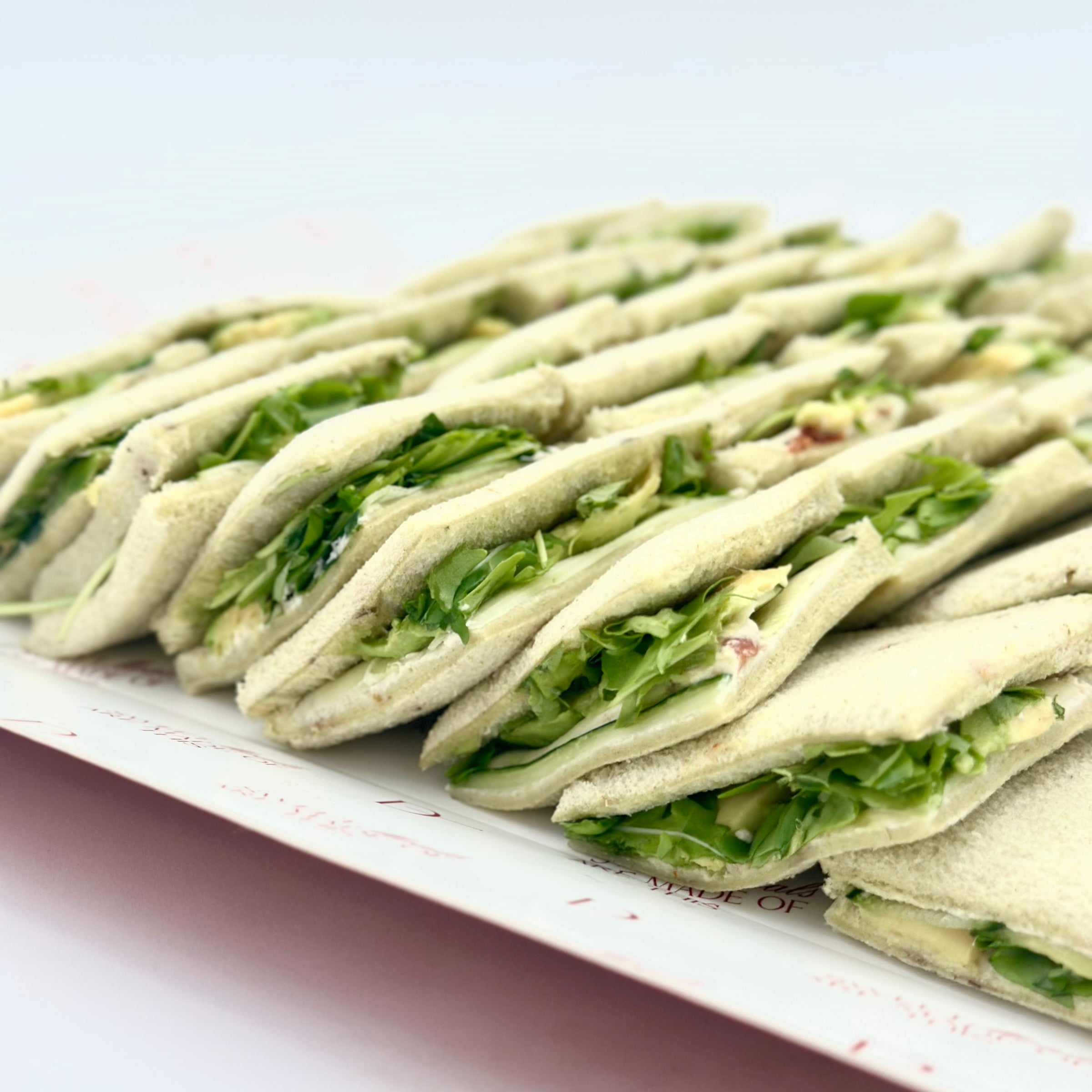 Pack de 8 mini sándwiches de pan de espinaca con aguacate, pepino, tomate seco, queso crema, pesto