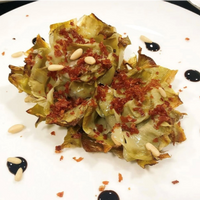 Duo de alcachofas confitadas con virutas de jamón ibérico y demi glace con setas